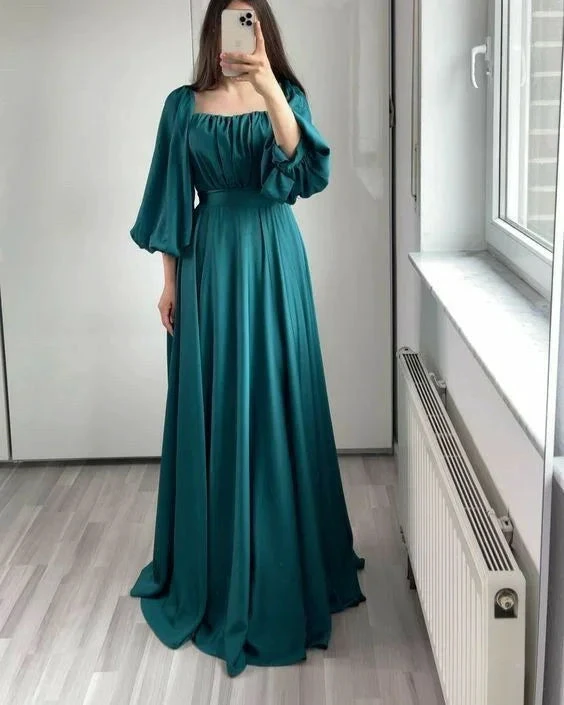 Woman in teal long maxi dress with puff sleeves taking mirror selfie in modern room