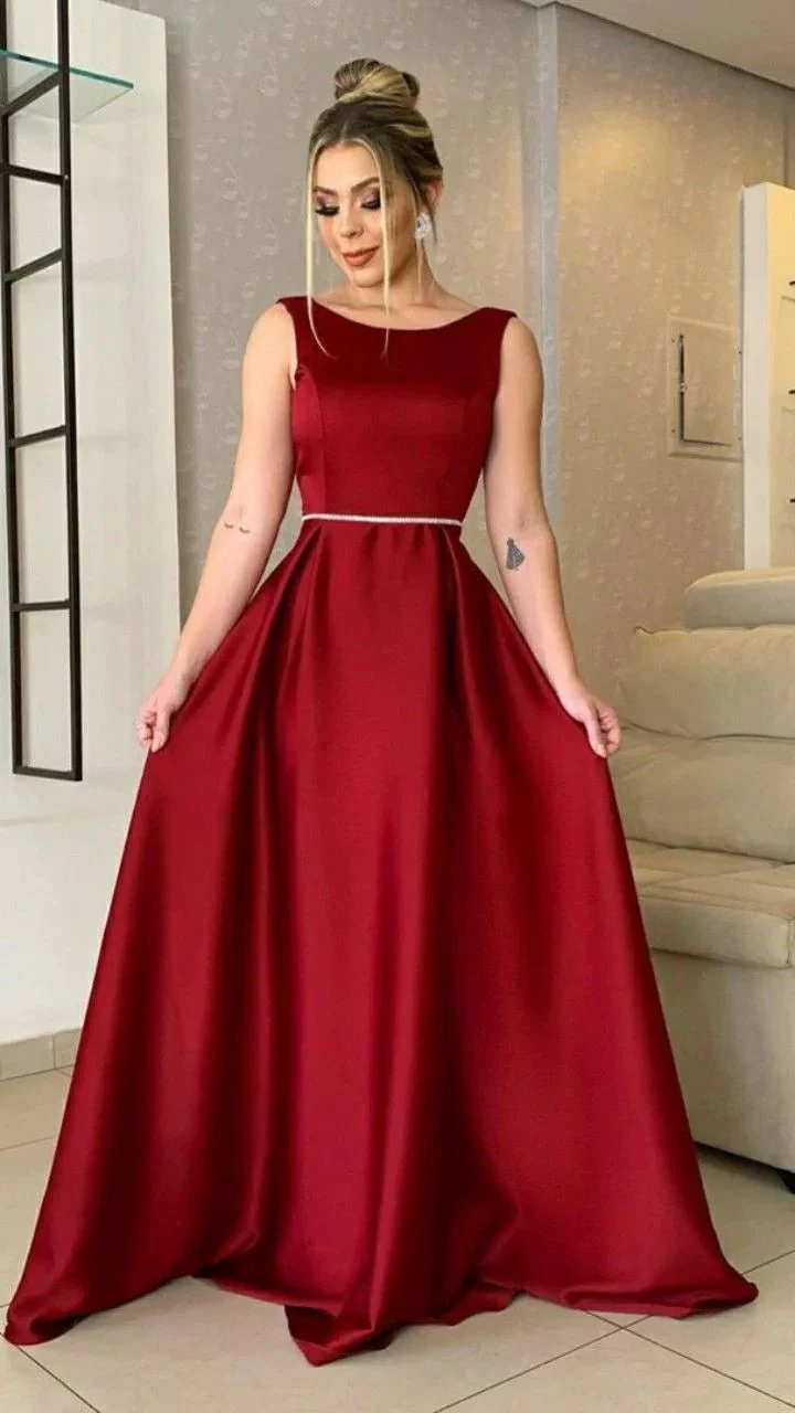 Woman in elegant red evening gown with belt, standing indoors for ZAPDRESS fashion.