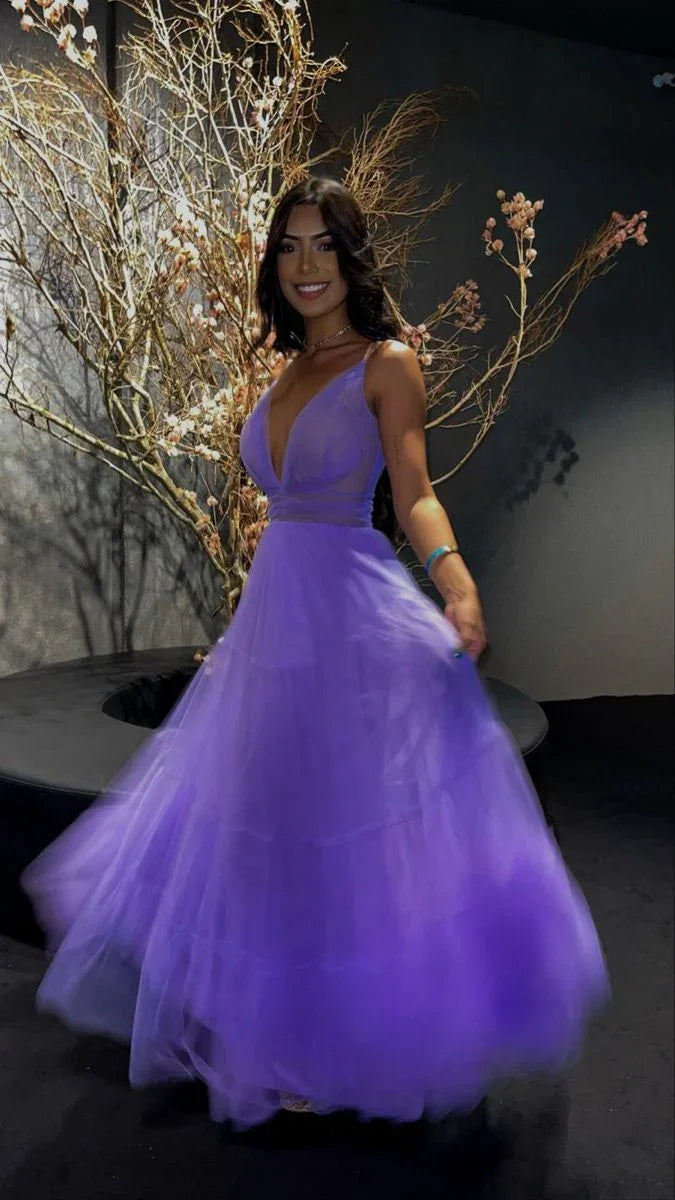 Woman in a flowing purple evening dress from ZAPDRESS, posing indoors by artistic branches.