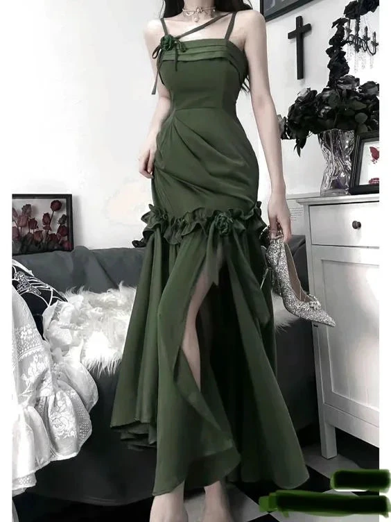 Woman in an elegant green evening dress with ruffles from ZAPDRESS, holding sparkling shoe