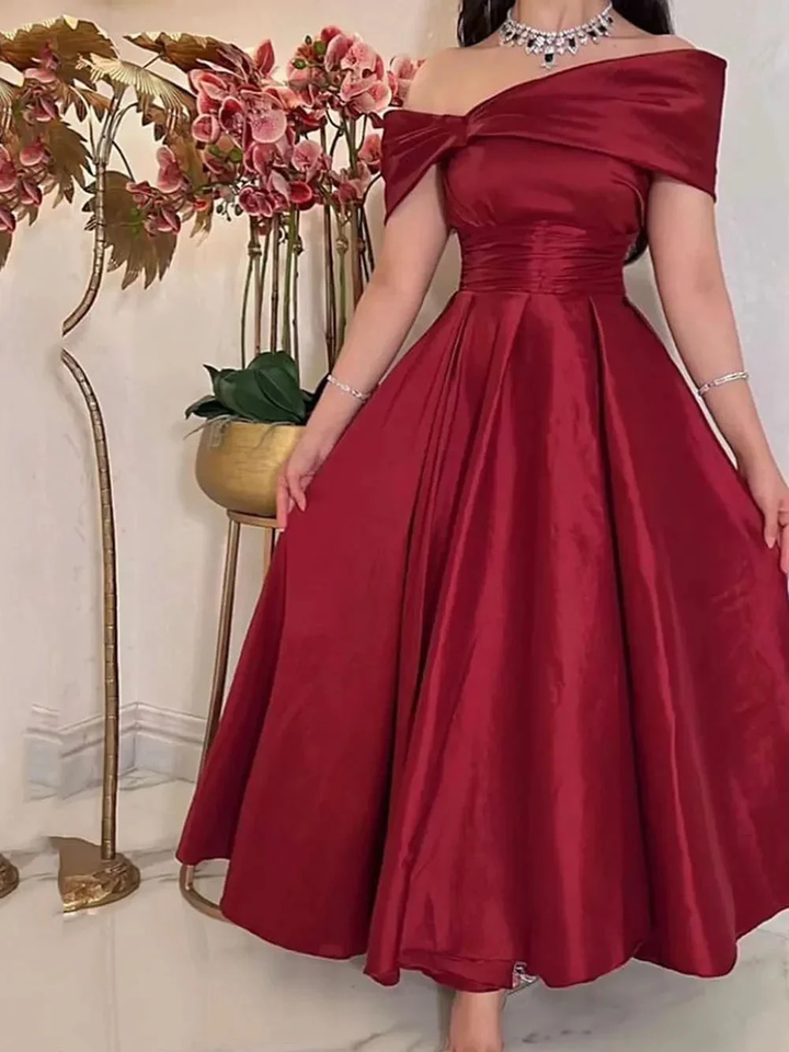 Elegant woman in off-shoulder red satin dress with floral backdrop at ZAPDRESS