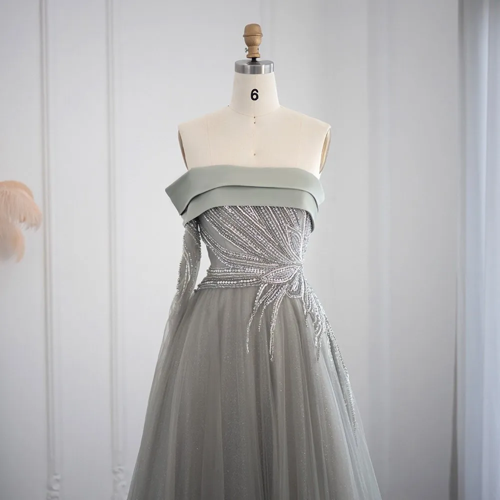 Abito da ballo a linea A con scollatura asimmetrica, maniche lunghe e decorato con paillettes