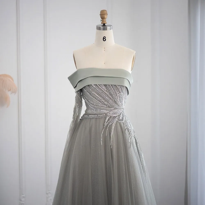 Abito da ballo a linea A con scollatura asimmetrica, maniche lunghe e decorato con paillettes