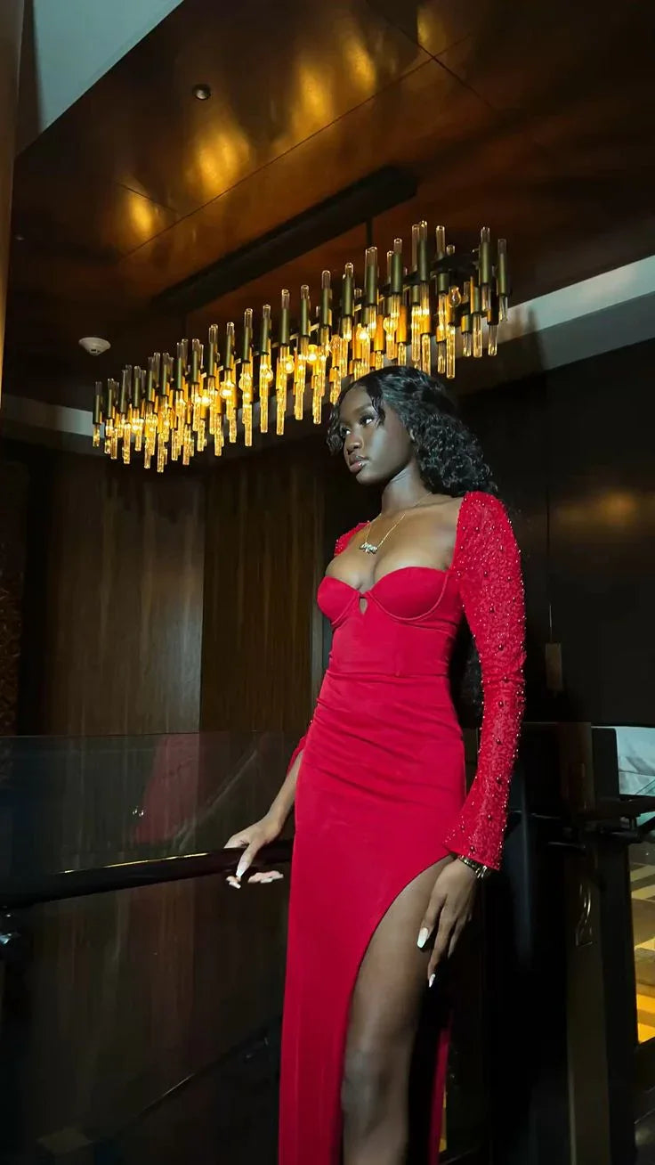 Woman in elegant red evening dress with thigh-high slit, posing indoors under modern chandelier, ZAPDRESS