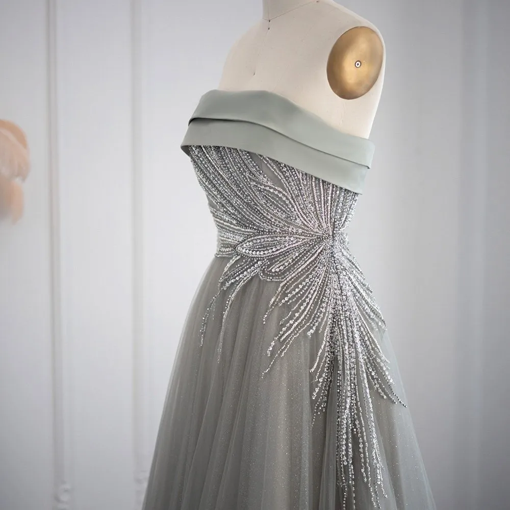 Abito da ballo a linea A con scollatura asimmetrica, maniche lunghe e decorato con paillettes