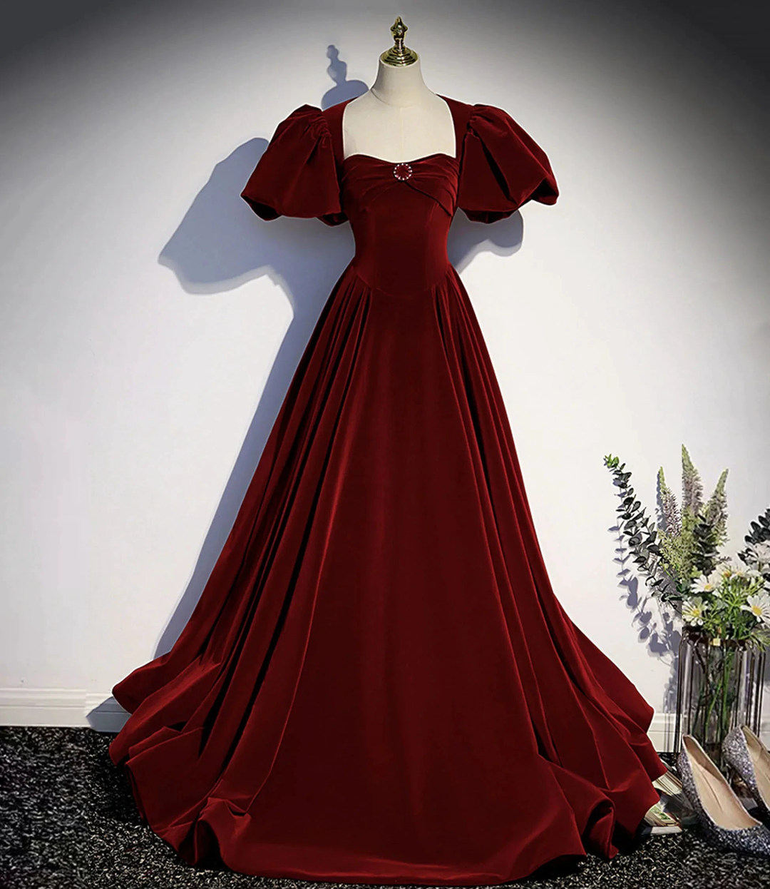 Elegant burgundy velvet ball gown with puff sleeves on mannequin, Zapdress fashion display