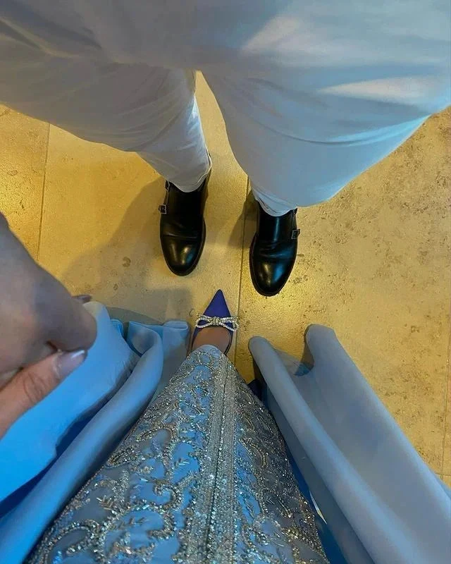 Elegant couple in blue dress and white pants with black shoes, holding hands, ZAPDRESS style
