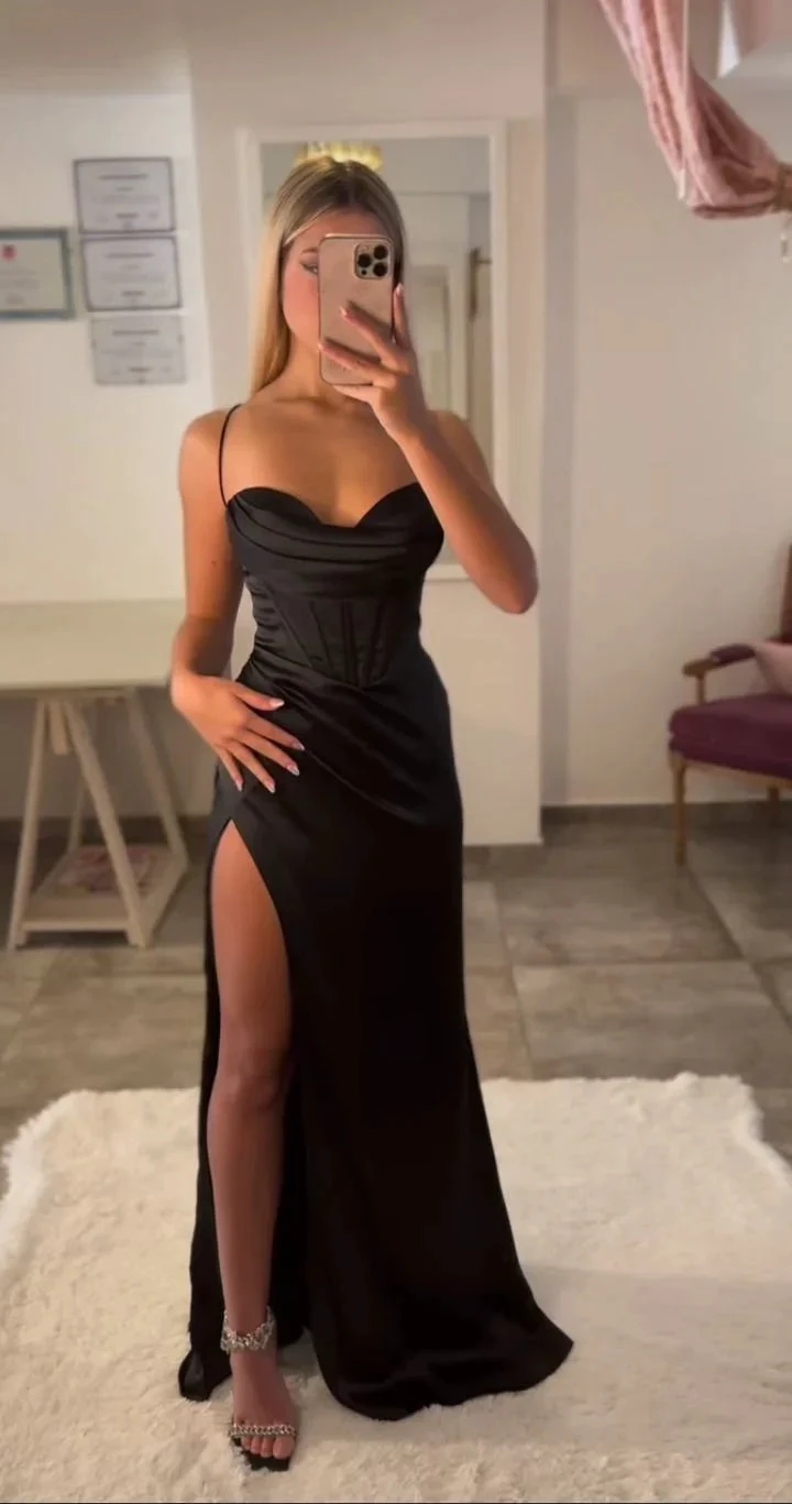 Woman wearing elegant black evening dress with thigh-high slit in modern room at ZAPDRESS