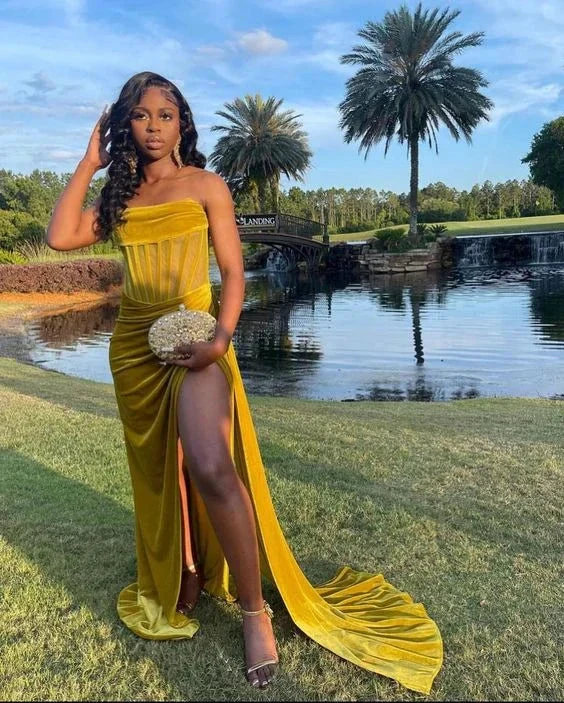 Woman in a gold velvet evening gown posing by a pond with palm trees at sunset, ZAPDRESS fashion