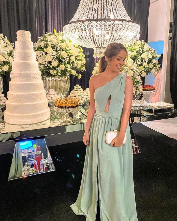 Woman in elegant mint green dress at formal event with large chandelier, floral arrangements, and tiered white cake, ZAPDRESS fashion