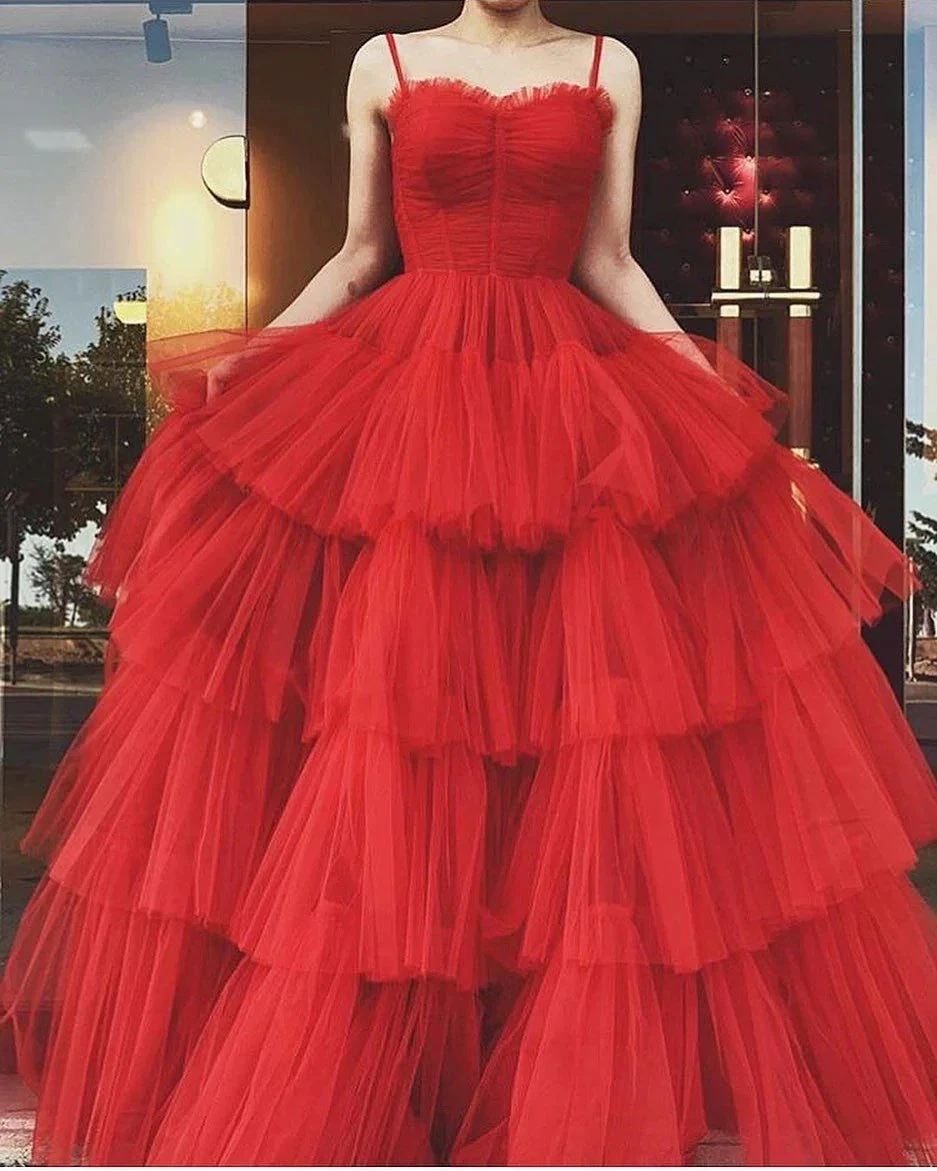 Woman modeling a layered red tulle evening gown in front of a store window, ZAPDRESS fashion