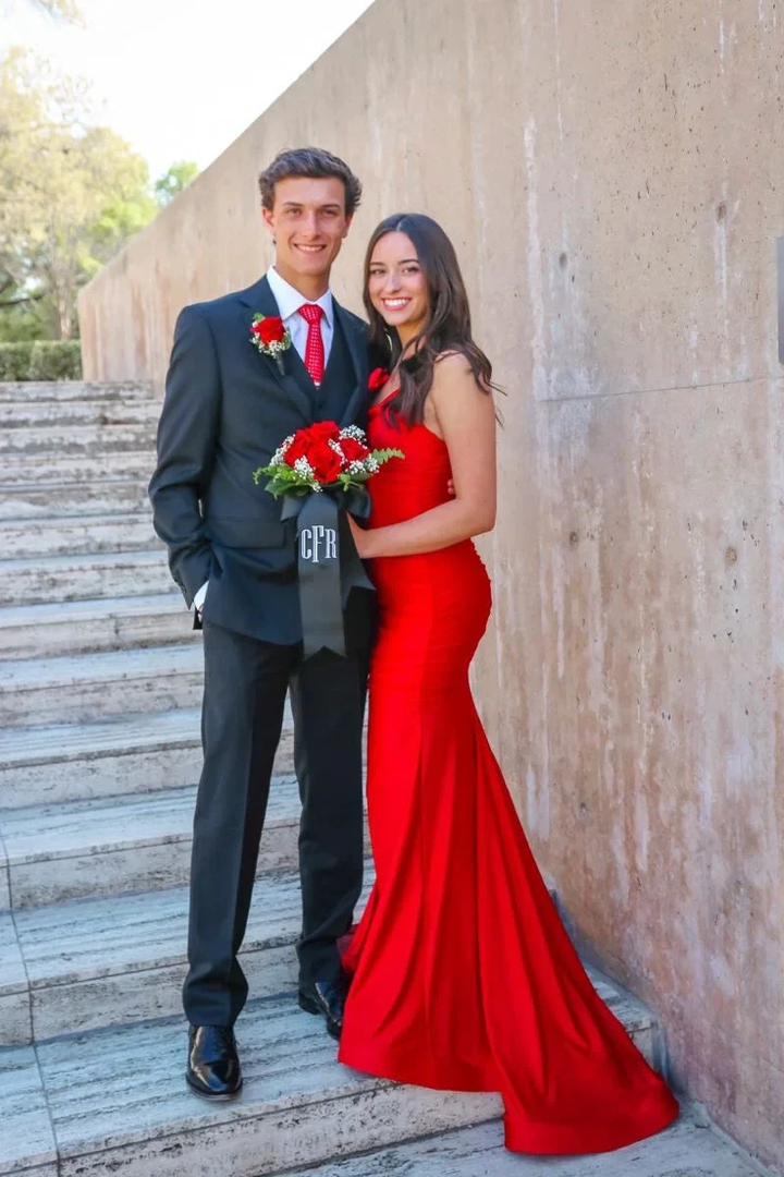 Couple posing outdoors, woman in red formal dress, man in suit with red tie and corsage, ZAPDRESS