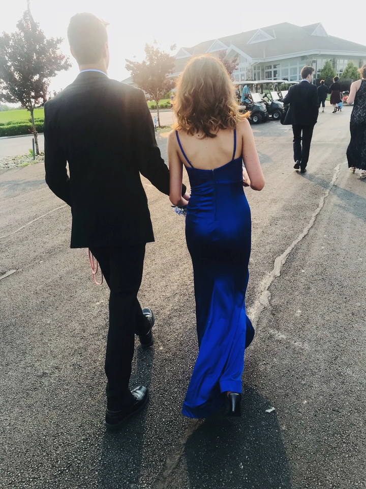 Couple walking outdoors, woman in elegant royal blue dress from ZAPDRESS collection