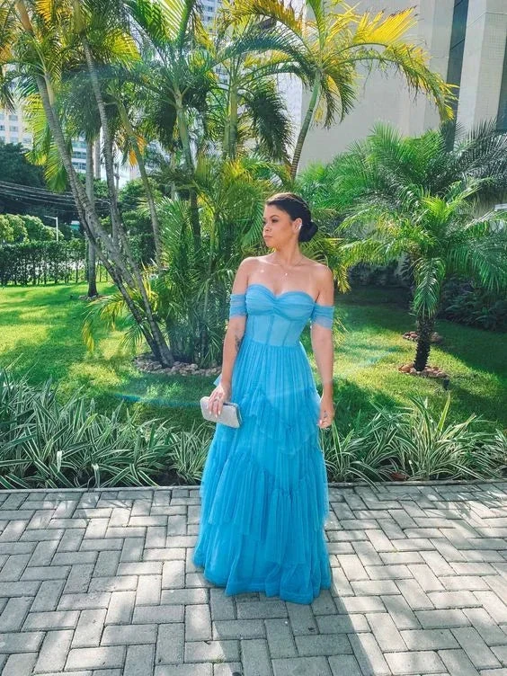 Woman in blue off-shoulder dress standing outdoors by palm trees, ZAPDRESS fashion