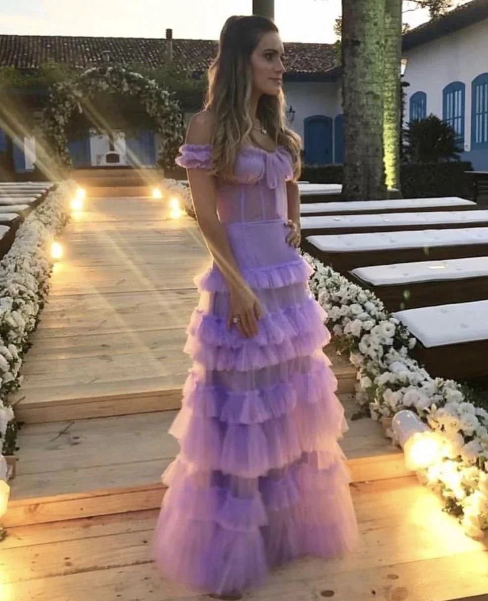 Woman in a lavender ruffle dress on floral-lit wooden walkway, ZAPDRESS fashion
