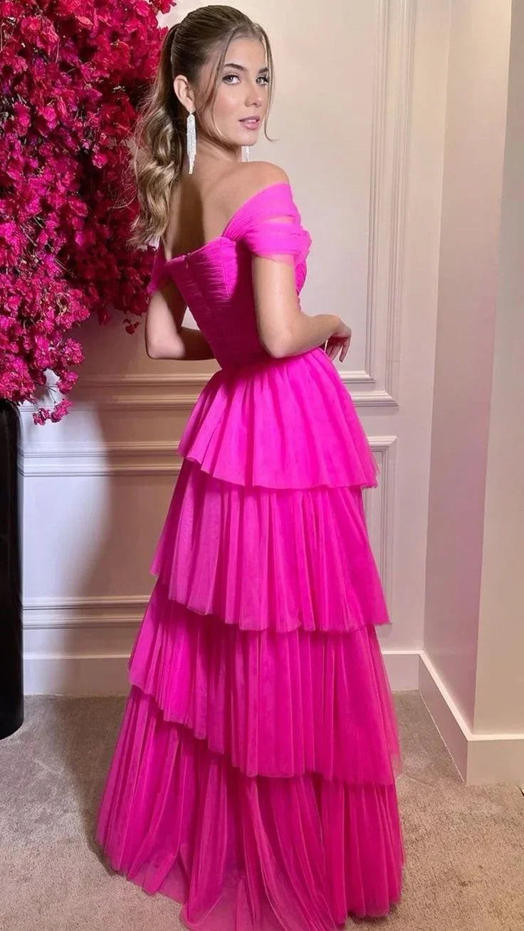 Woman in tiered hot pink off-shoulder dress by ZAPDRESS, standing by pink flowers