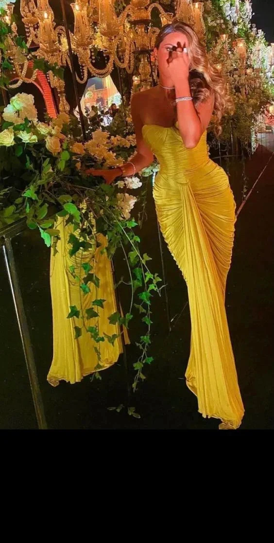 Woman in elegant yellow evening dress at floral, chandelier-lit ZAPDRESS event