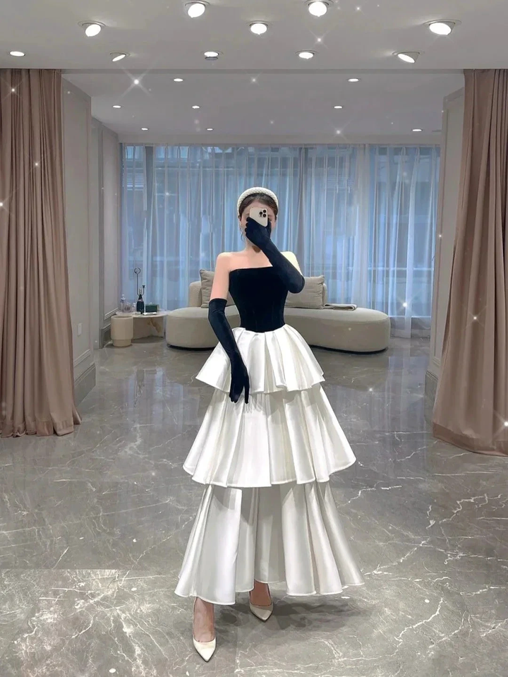 Woman in tiered white ruffle skirt and black strapless top posing indoors, ZAPDRESS fashion
