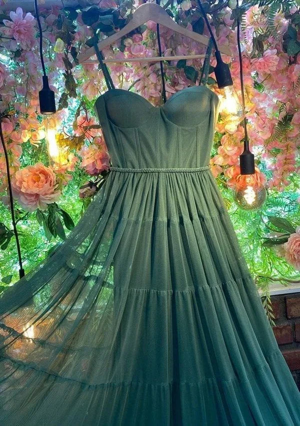 Green tulle dress on hanger, floral background, ambient lights, ZAPDRESS fashion