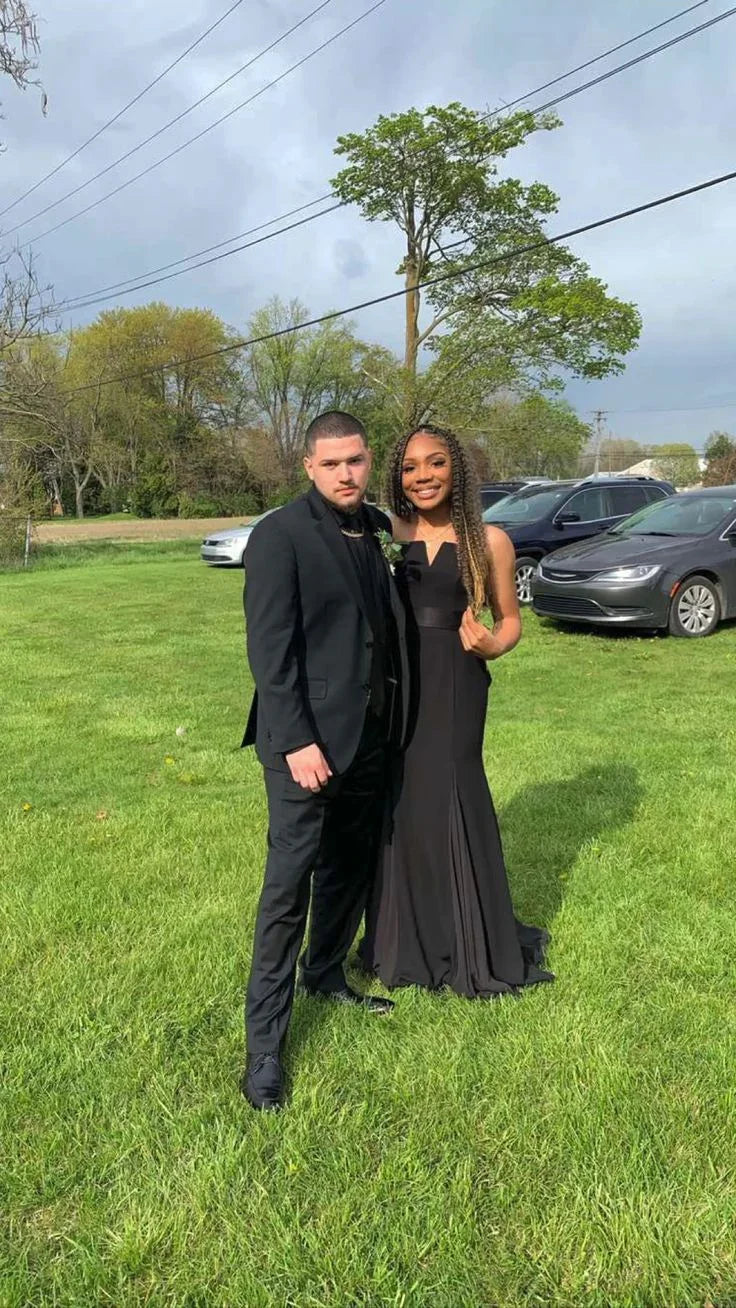 Couple in formal black outfits posing on grass, ZAPDRESS elegant evening fashion