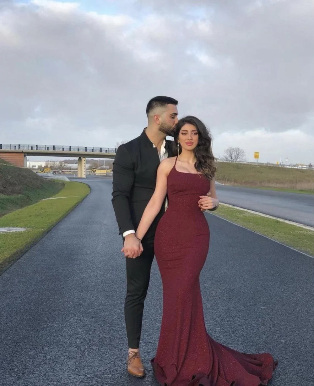 Couple posing outdoors, woman in burgundy evening gown, elegant fashion by ZAPDRESS