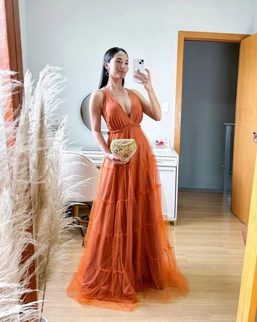 Woman in orange formal dress taking mirror selfie in modern bedroom, Zapdress fashion.