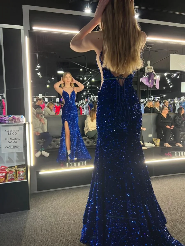 Woman in a sparkly royal blue evening gown with high slit at ZAPDRESS boutique mirror