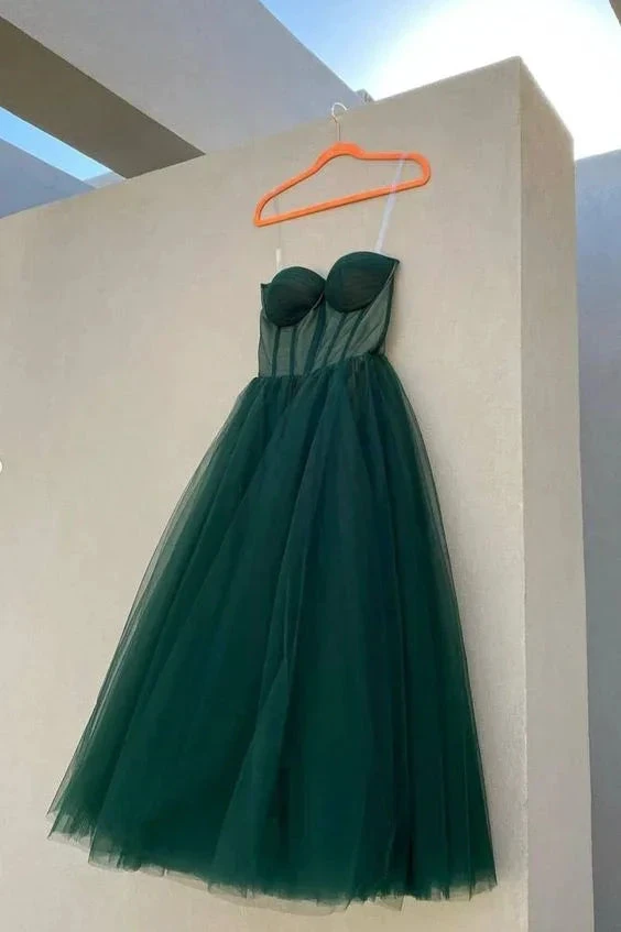 Elegant dark green tulle dress with structured bodice on hanger, outdoor setting, ZAPDRESS