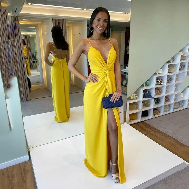Woman in bright yellow evening gown with slit, posing in boutique, ZapDress fashion.