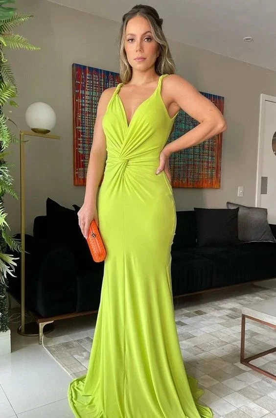 Woman in bright green evening gown holding orange clutch in modern living room, ZAPDRESS fashion