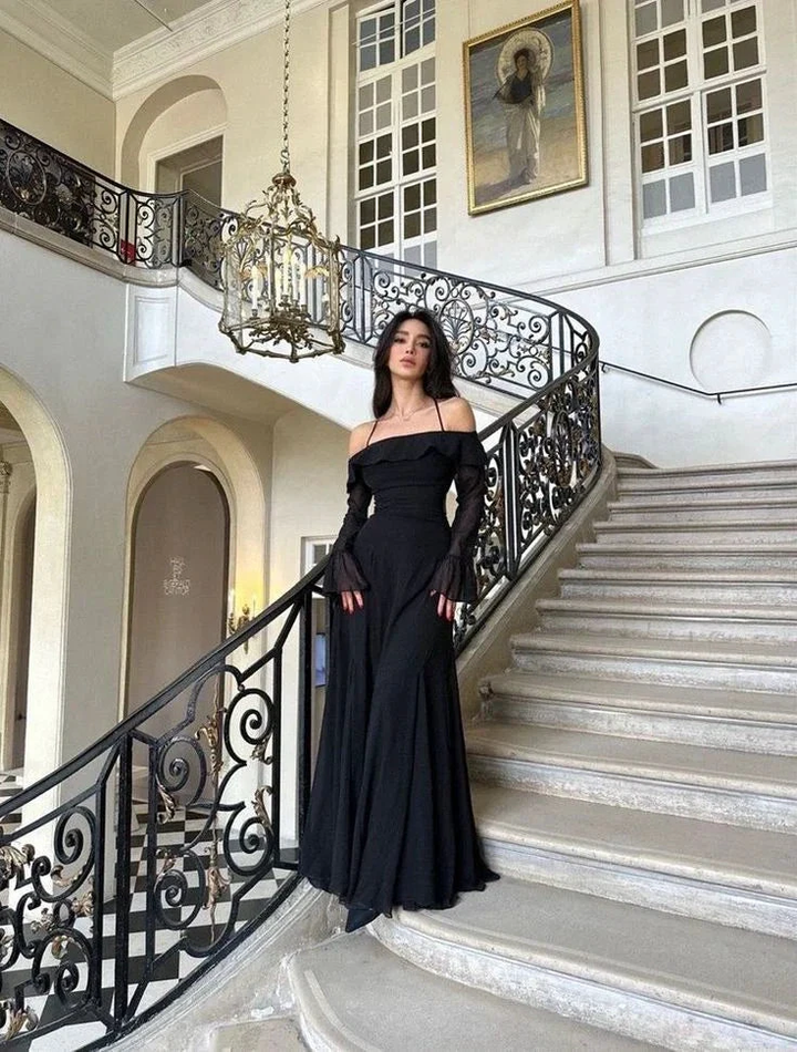 Woman in elegant black evening gown on grand staircase, ZAPDRESS fashion main hall
