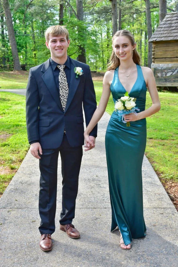 Couple in formal wear outdoors, woman in teal dress holding flowers, ZAPDRESS fashion