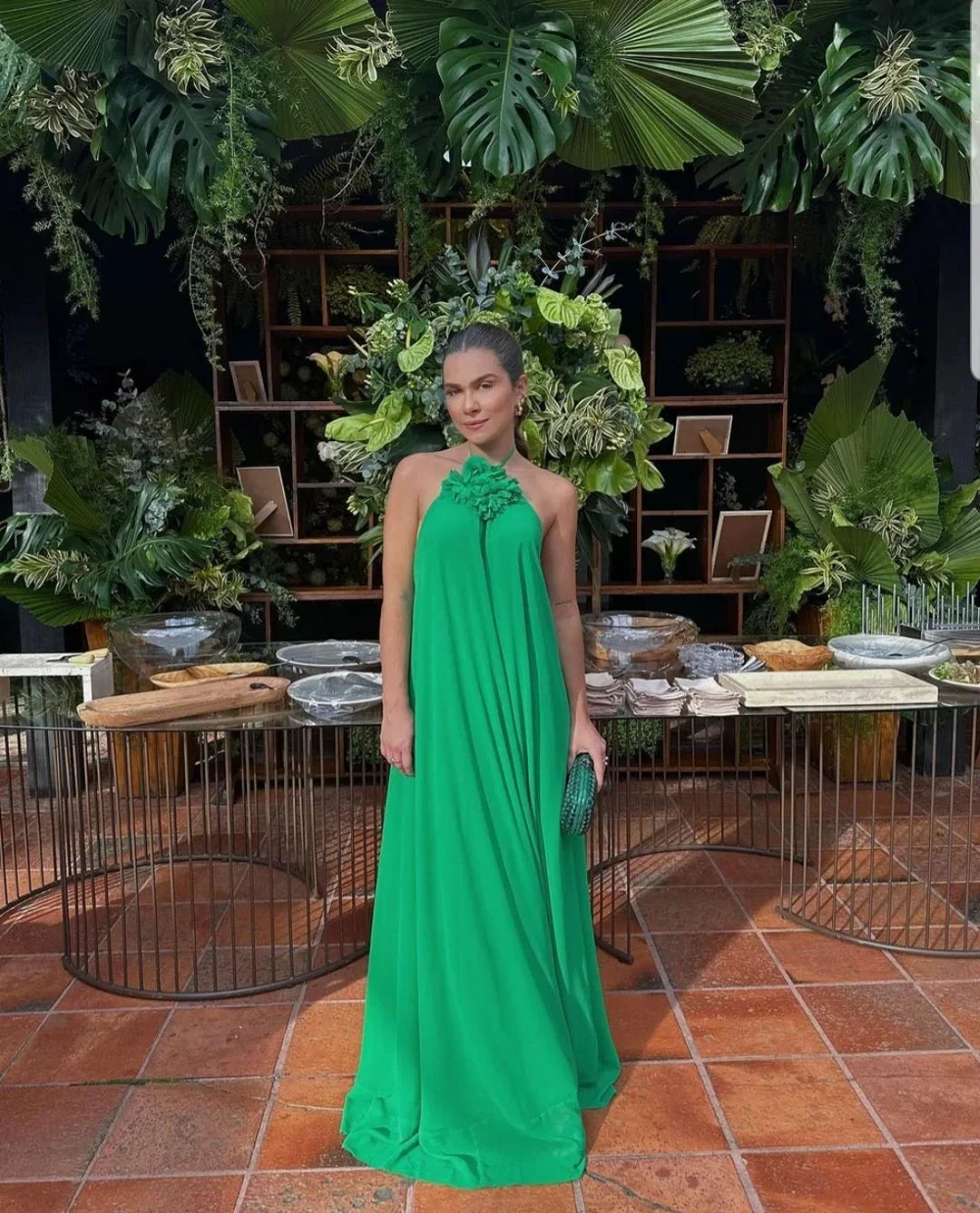 Woman in a flowing green dress at a tropical event, surrounded by lush greenery, ZAPDRESS