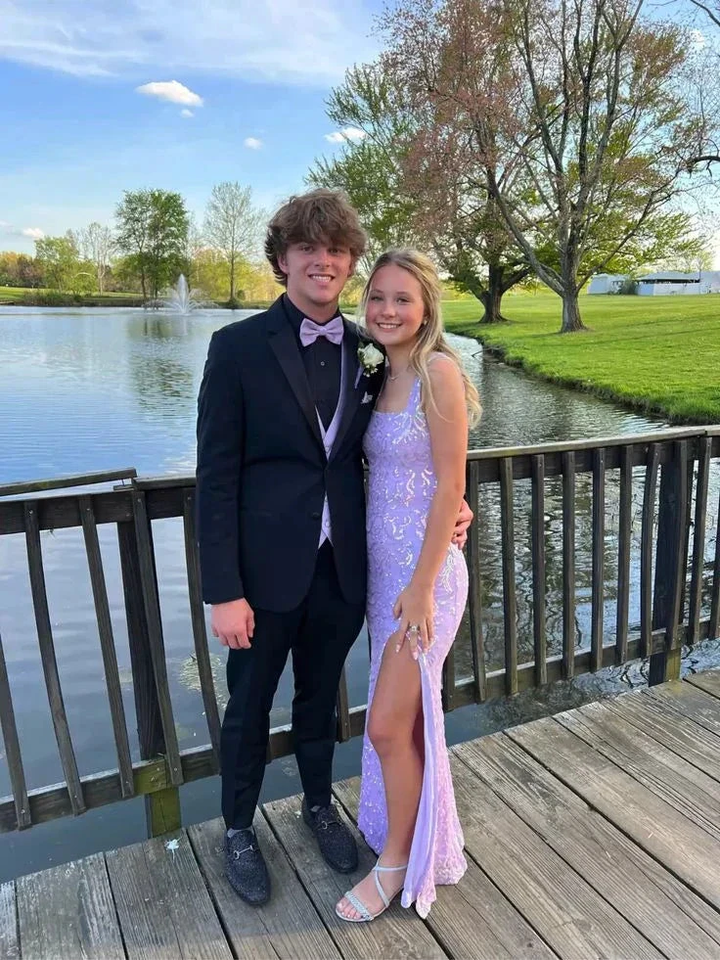 Couple posing by a lakeside in formal prom attire, featuring a sparkly lilac dress