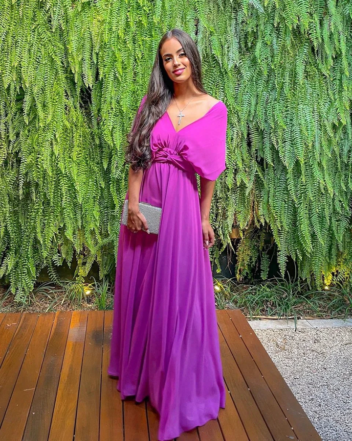 Woman in a vibrant purple maxi dress standing on a wooden deck, lush green ferns behind her, ZAPDRESS