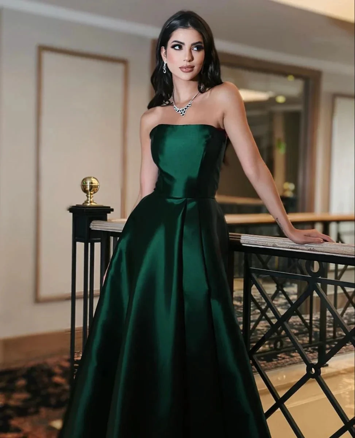Woman in elegant strapless emerald green evening gown at indoor event, ZAPDRESS fashion