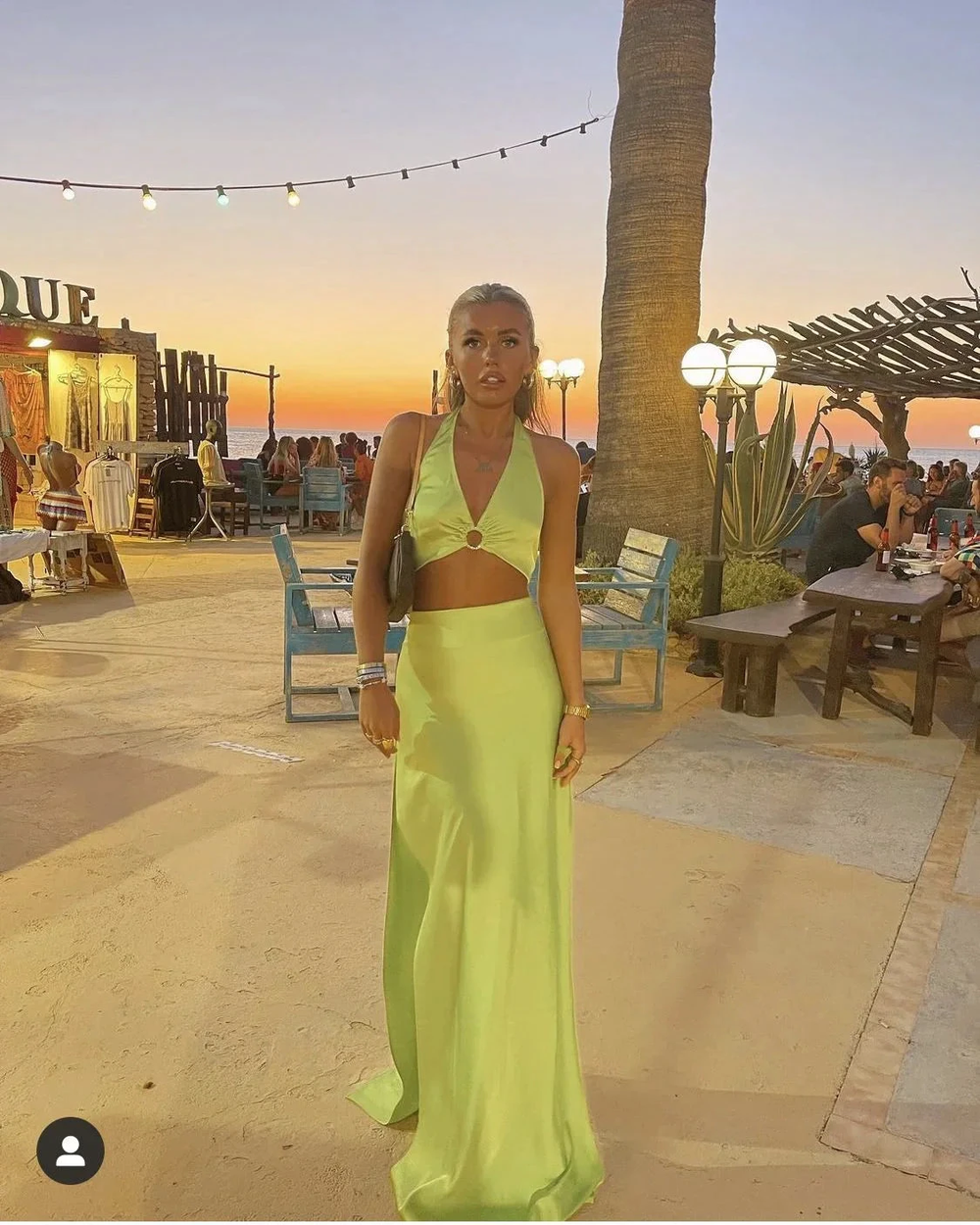 Woman in lime green satin maxi dress at outdoor beachside venue at sunset, ZAPDRESS fashion