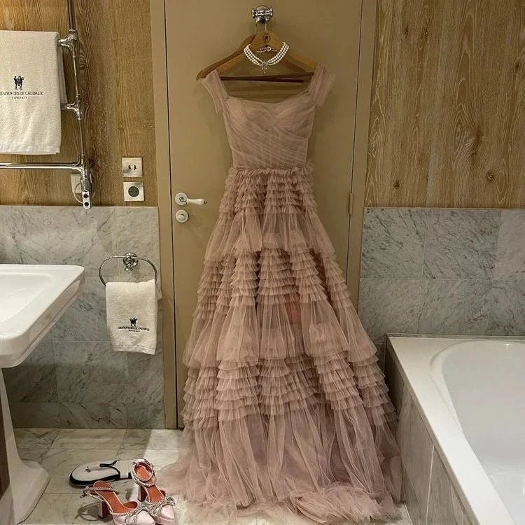 Elegant pink tulle tiered evening dress hanging in marble bathroom, ZAPDRESS fashion