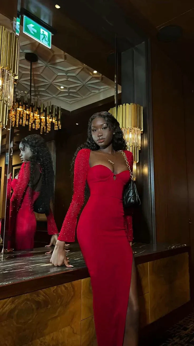 Woman in a glamorous red evening dress posing in a modern, elegant interior for ZAPDRESS
