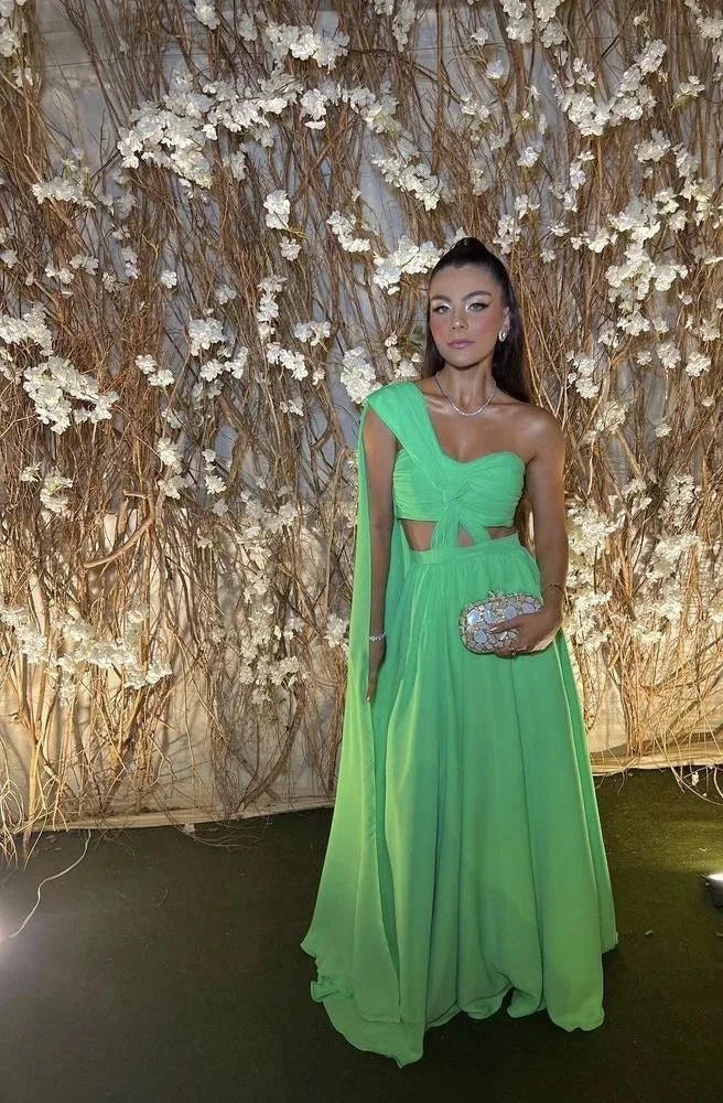 Woman in bright green evening gown with jeweled clutch at ZAPDRESS floral backdrop event