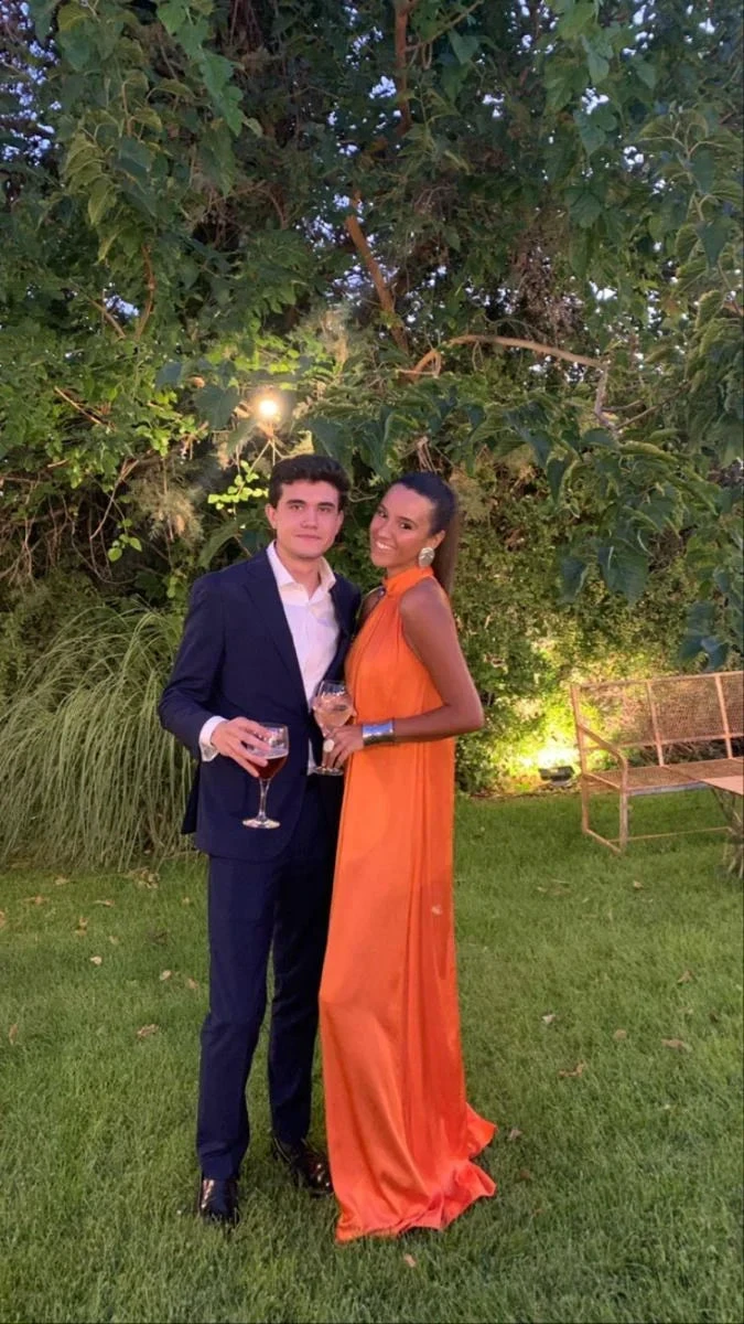 Elegant couple at outdoor event, woman in orange evening dress, stylish fashion, ZAPDRESS