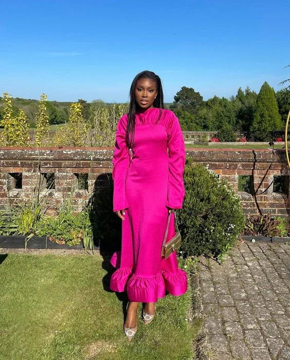 Woman in bright pink ruffle dress standing outdoors, garden background, ZAPDRESS fashion