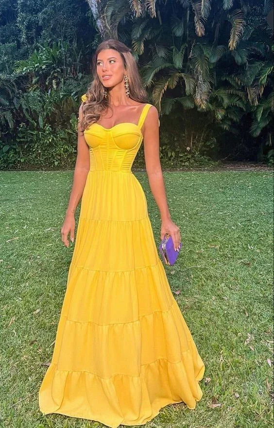 Woman in bright yellow maxi dress from ZAPDRESS standing outdoors on green grass