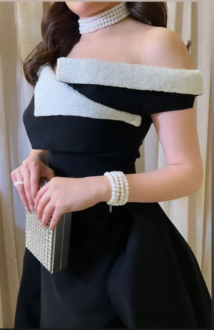 Elegant black off-shoulder dress with white textured trim, pearl jewelry, and a beaded clutch from ZAPDRESS
