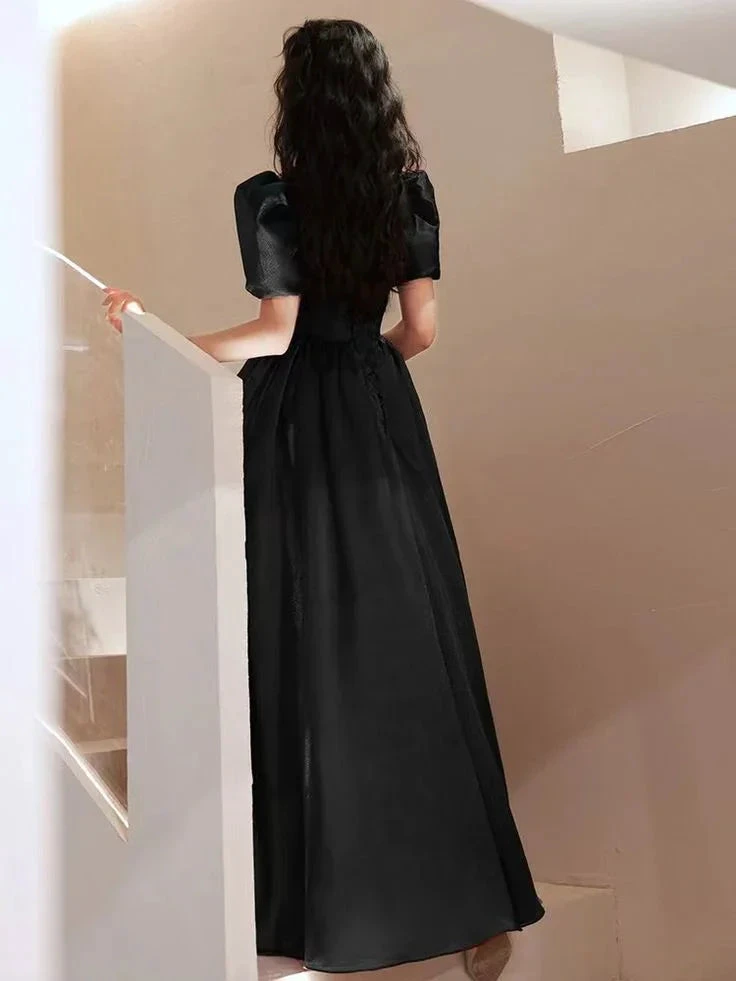 Woman in long black dress with puff sleeves standing on stairs, ZAPDRESS fashion