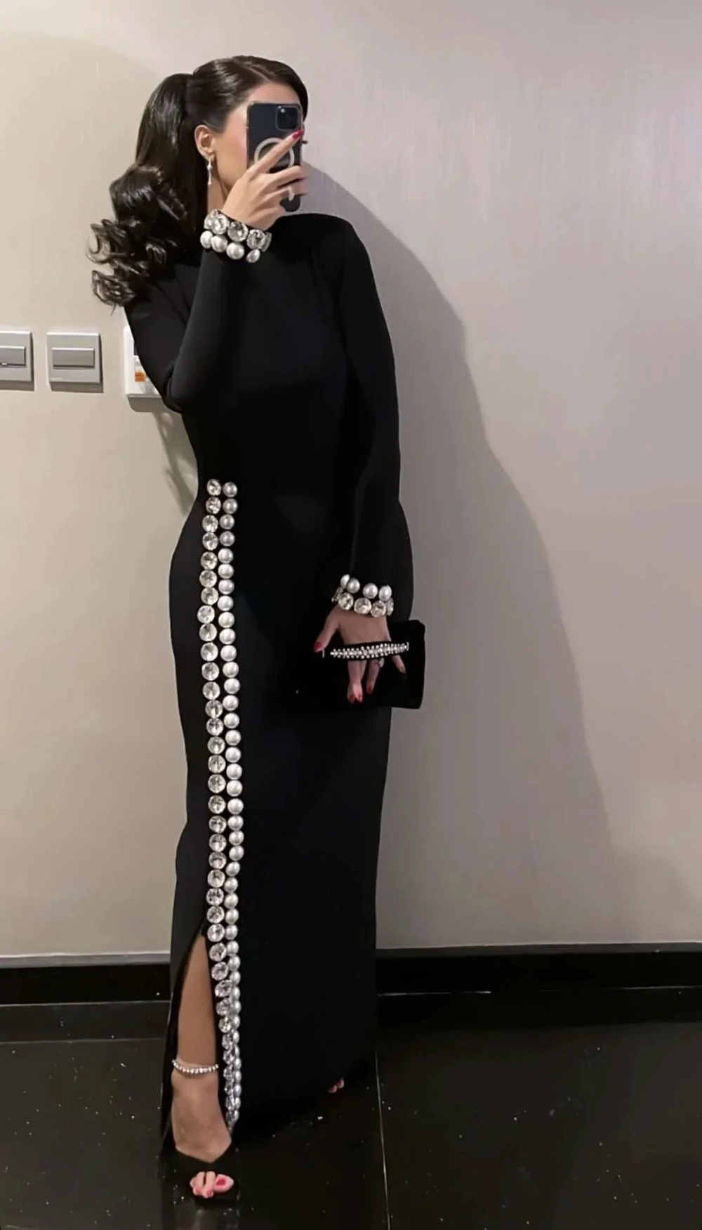 Elegant woman in black dress with pearl embellishments, holding clutch, ZAPDRESS fashion