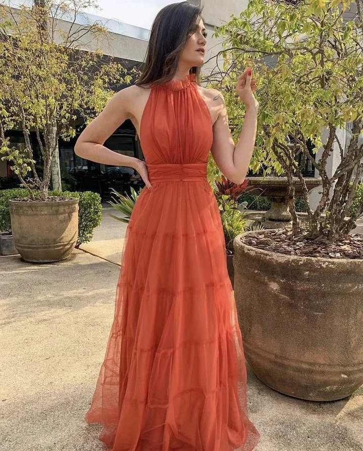 Woman wearing an elegant orange halter maxi dress outdoors, ZAPDRESS fashion style