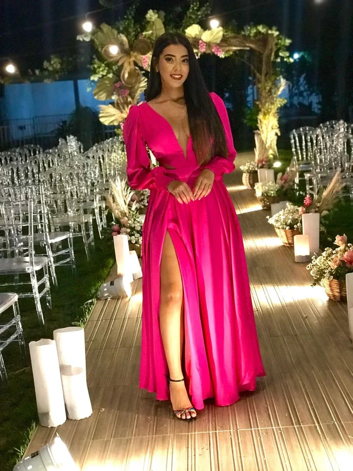 Woman in vibrant pink evening dress at elegant outdoor event, floral arch and clear chairs