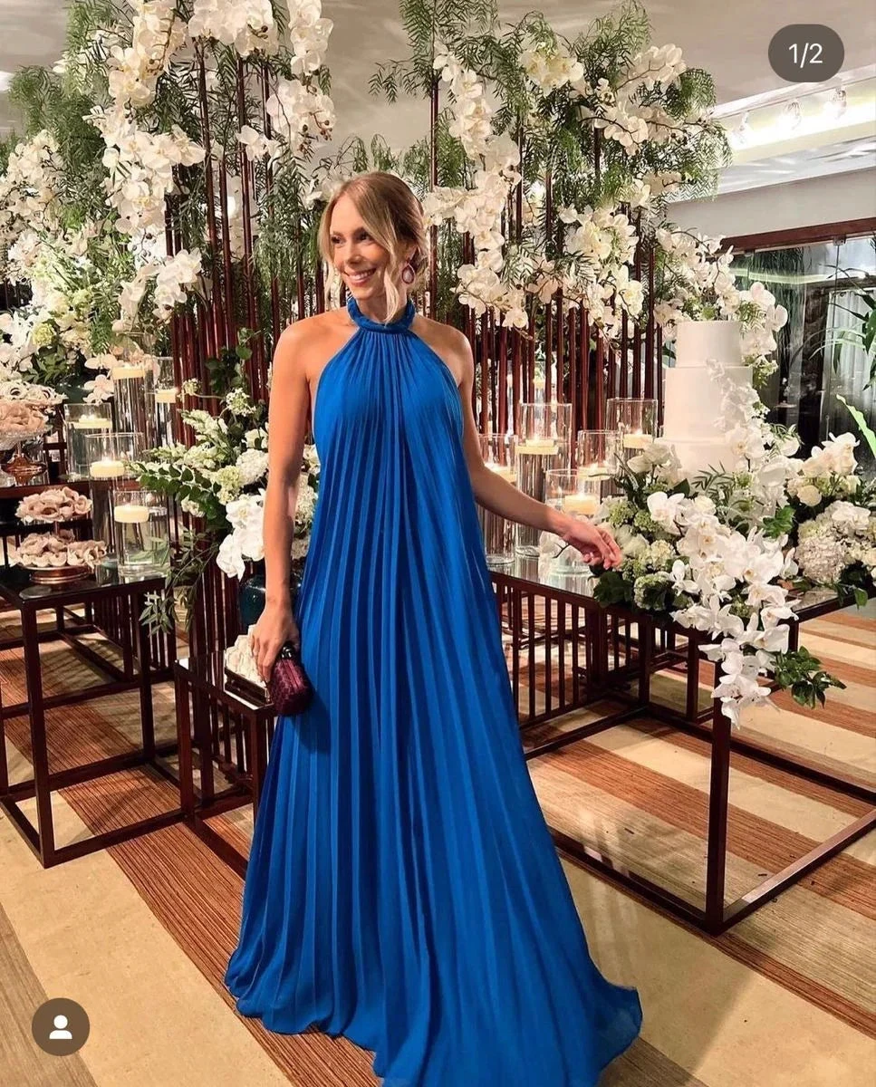 Woman in elegant blue halter gown at floral event, ZAPDRESS formal dress fashion