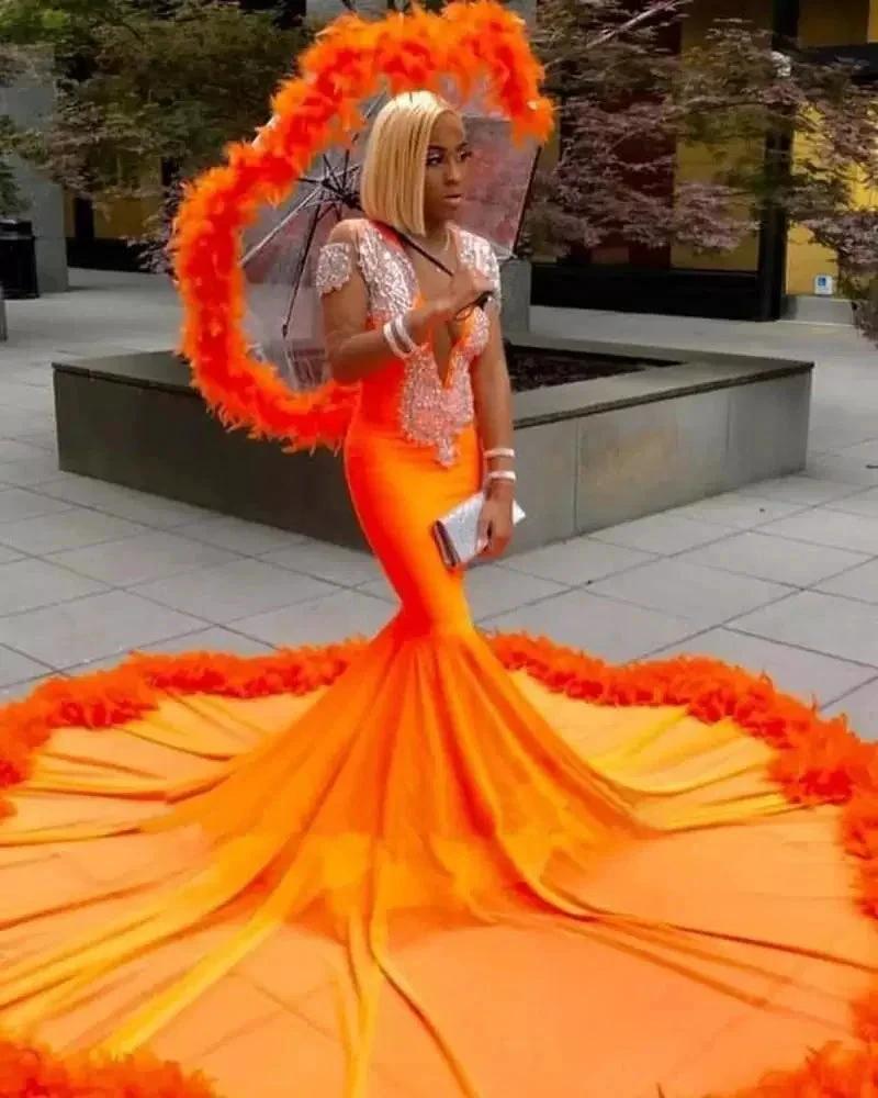 Splendido abito da sera arancione con scollo a V, pizzo e frange, maniche lunghe, stile sirena